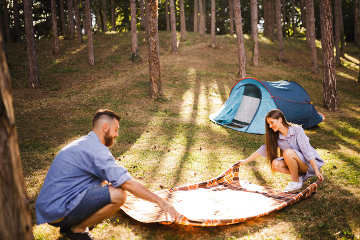 Young couple preapring for camping in forest